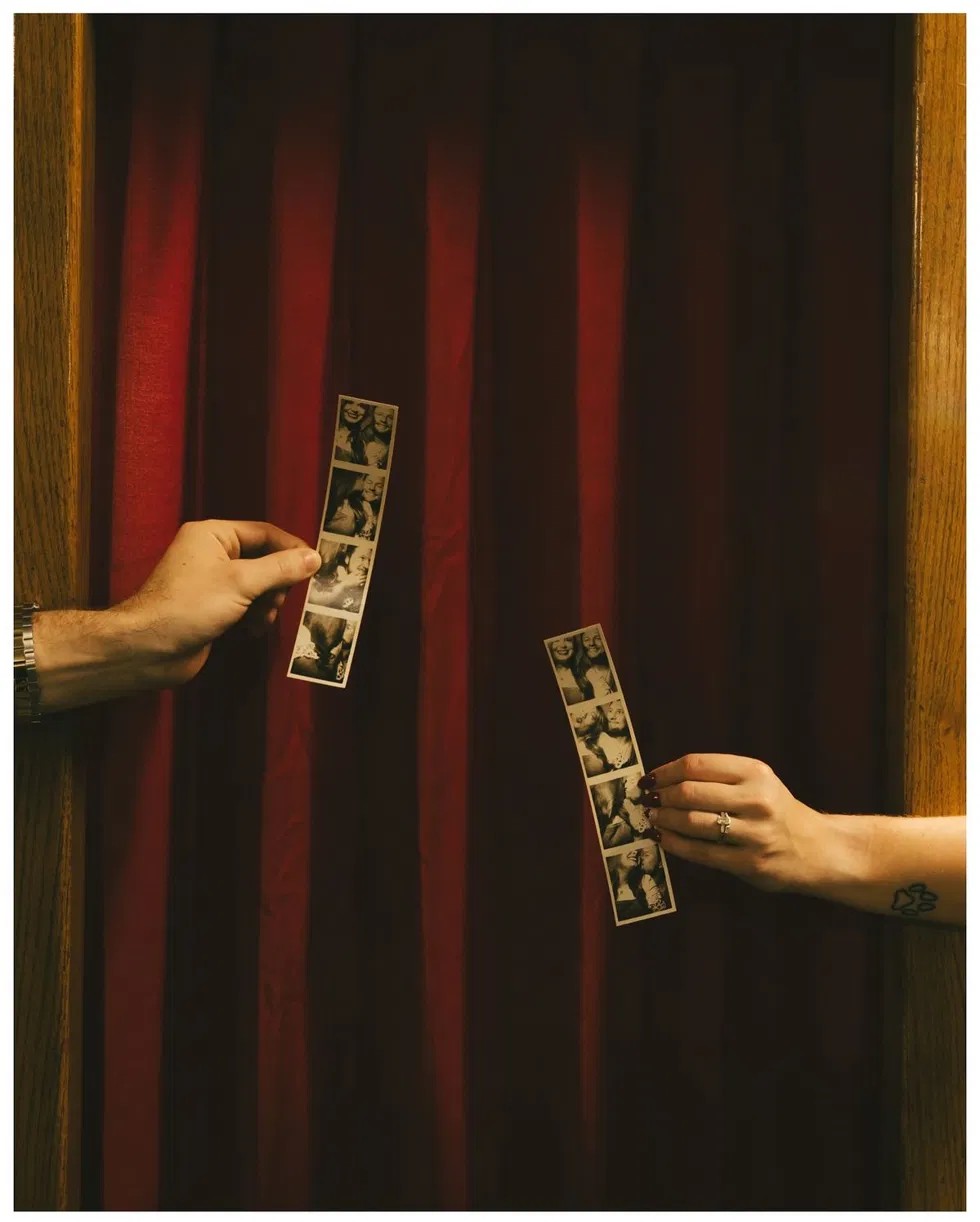 Guests exchanging photobooth strips at The Guestbook Gallery